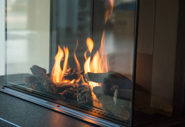 A gas fireplace with burning logs, illustrating the importance of regular maintenance for home safety.