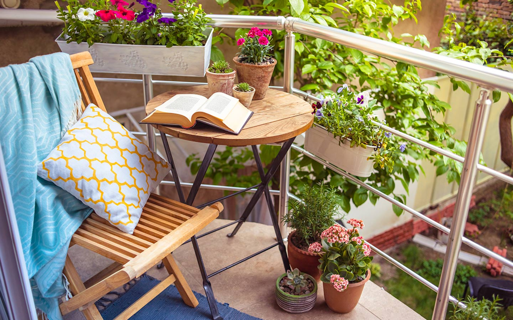 Cozy small balcony seating with cushions and plants